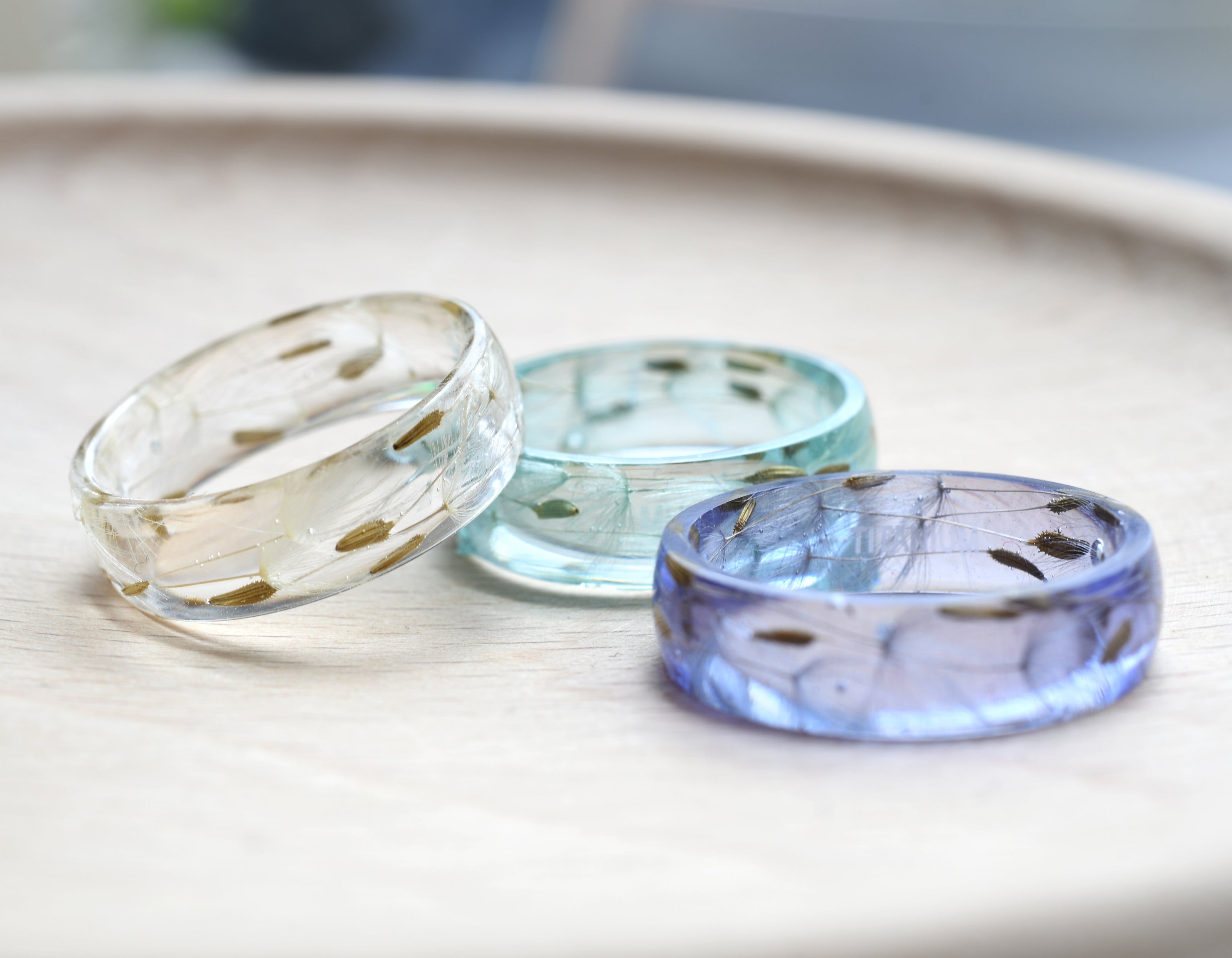Trio of wish rings in lavender, blue, and clear resin