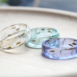 Trio of wish rings in lavender, blue, and clear resin