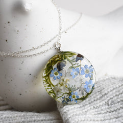 Woodland necklace with two tiny mushrooms, real moss, and flowers in a 25 mm terrarium pendant