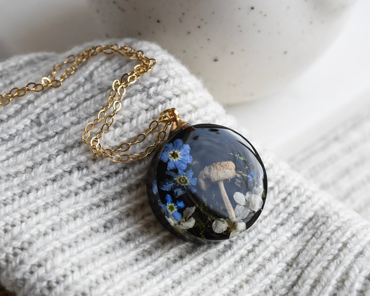 Woodland terrarium necklace with real moss, mushroom, and flowers preserved in resin