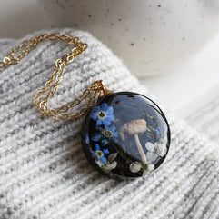 Woodland terrarium necklace with real moss, mushroom, and flowers preserved in resin