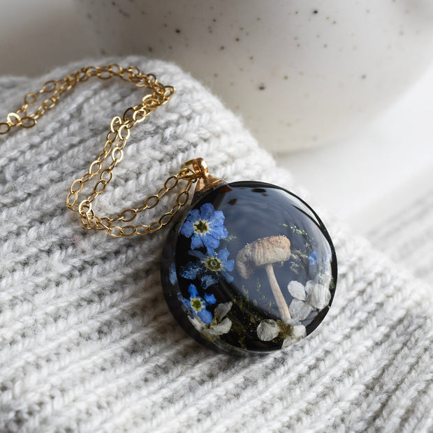 Woodland terrarium necklace with real moss, mushroom, and flowers preserved in resin
