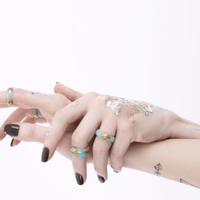 Mint ring with gold flakes on hands
