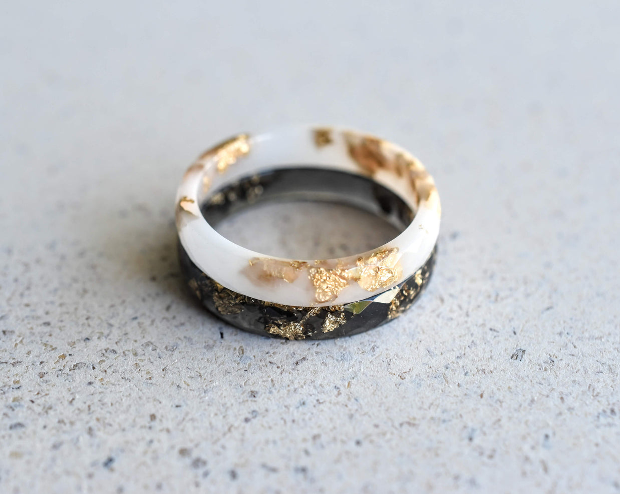 Handmade black and white resin rings with gold leaf — modern unisex jewelry crafted in Vienna by Resity