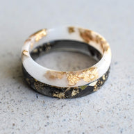 Handmade black and white resin rings with gold leaf — modern unisex jewelry crafted in Vienna by Resity