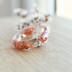 Close-up of metallic copper flakes in clear resin ring