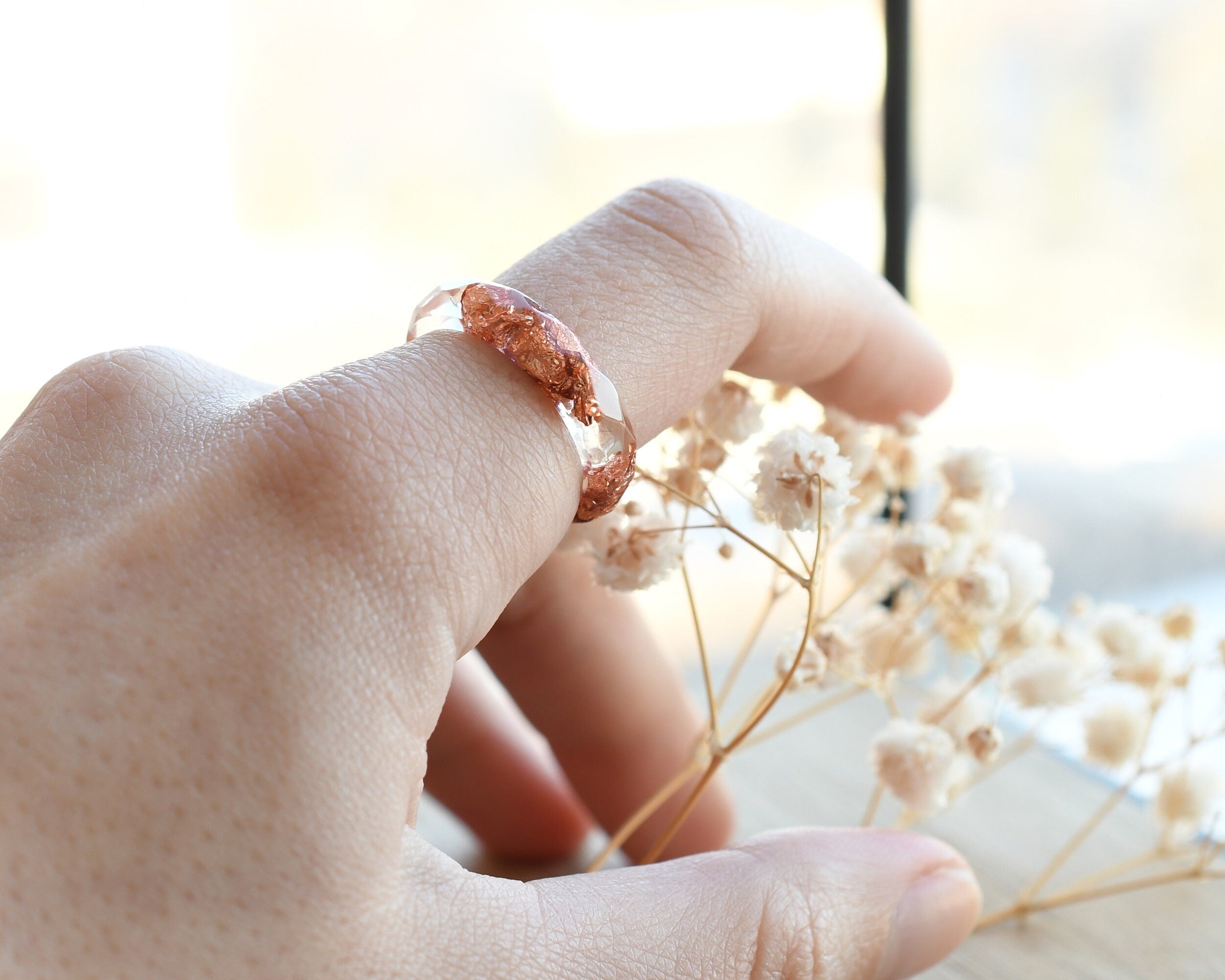 Stacked clear and copper resin ring worn on hand