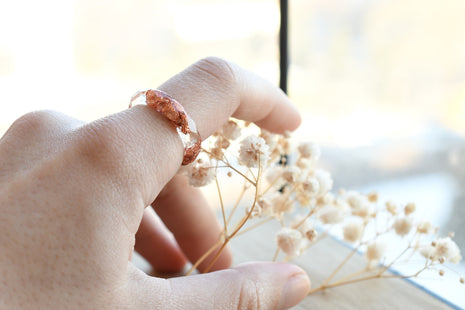 Stacked clear and copper resin ring worn on hand
