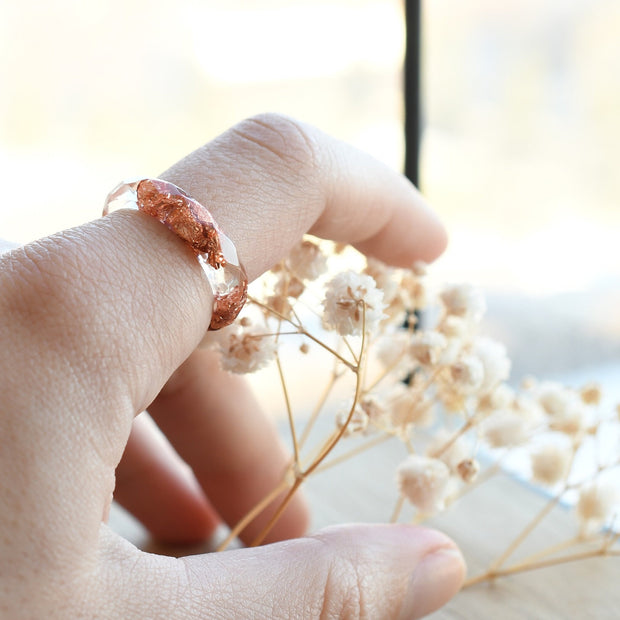 Stacked clear and copper resin ring worn on hand