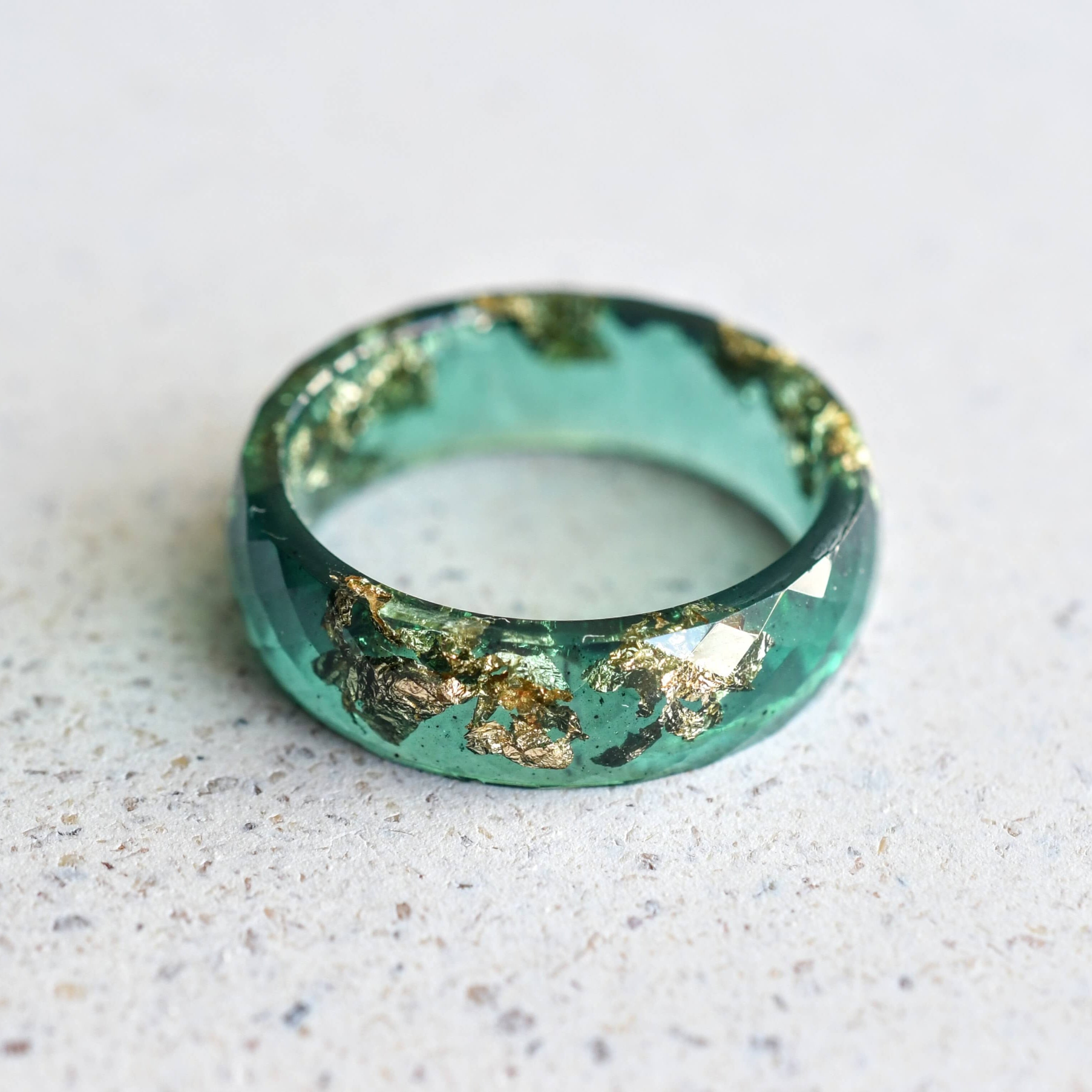 Flatlay of Deep Grove Ring with gold shimmer in emerald green resin