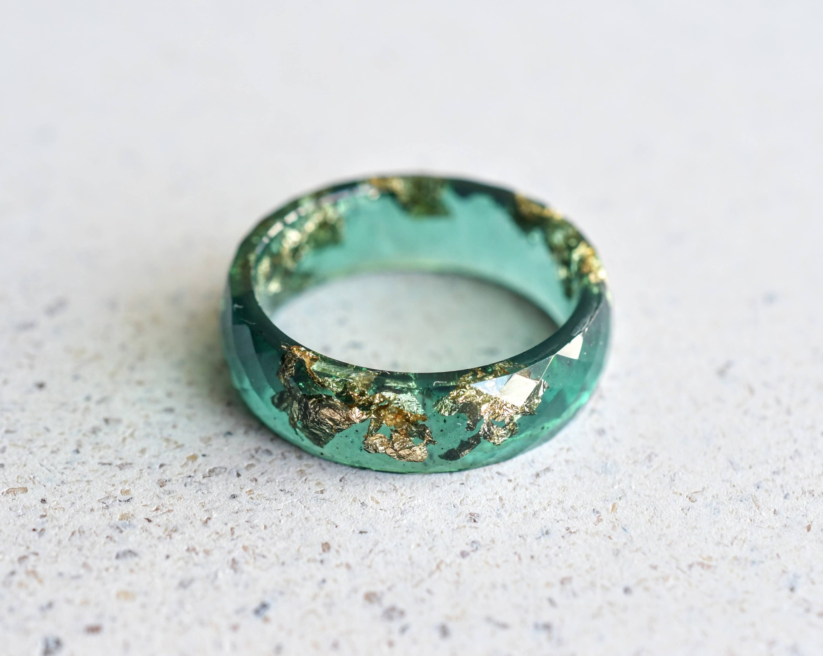 Flatlay of Deep Grove Ring with gold shimmer in emerald green resin