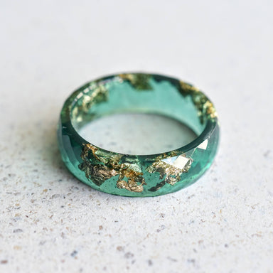 Flatlay of Deep Grove Ring with gold shimmer in emerald green resin