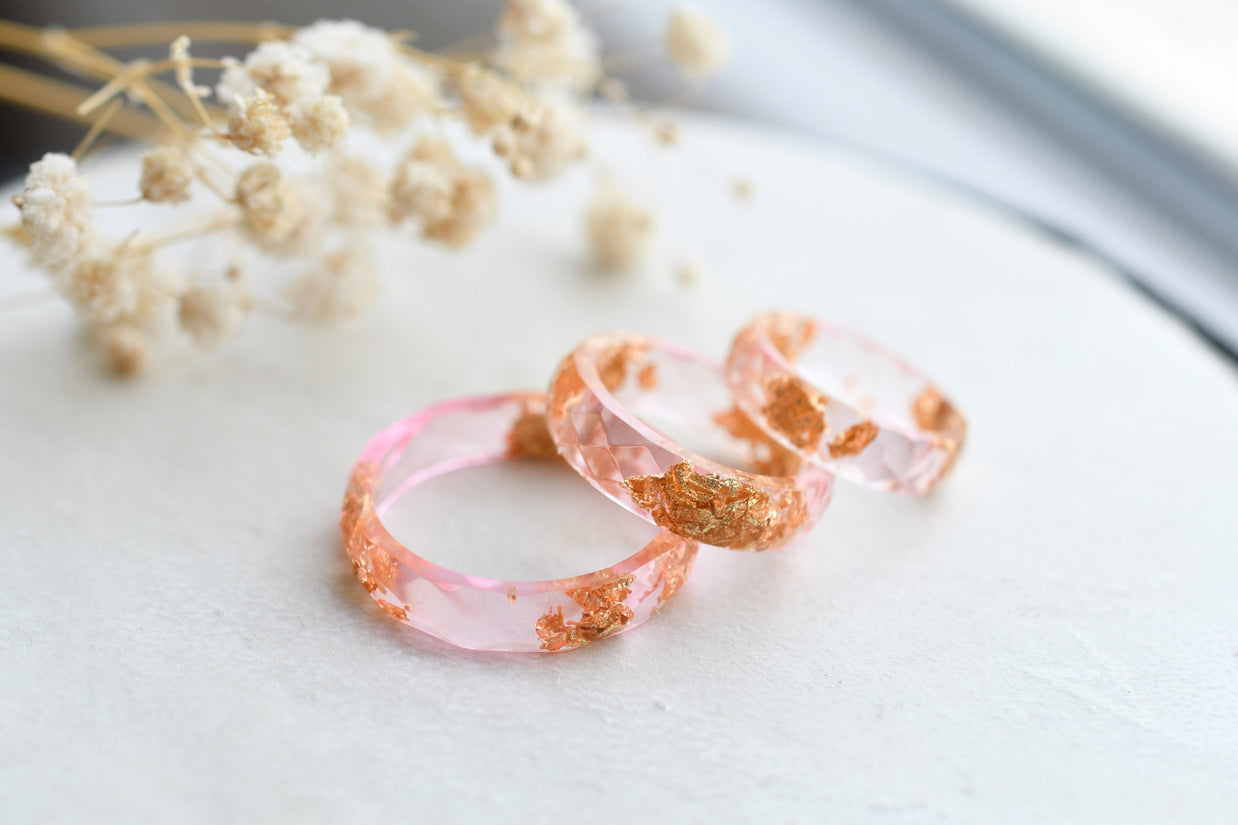 Close-up of gold flakes suspended in clear pink resin handmade ring