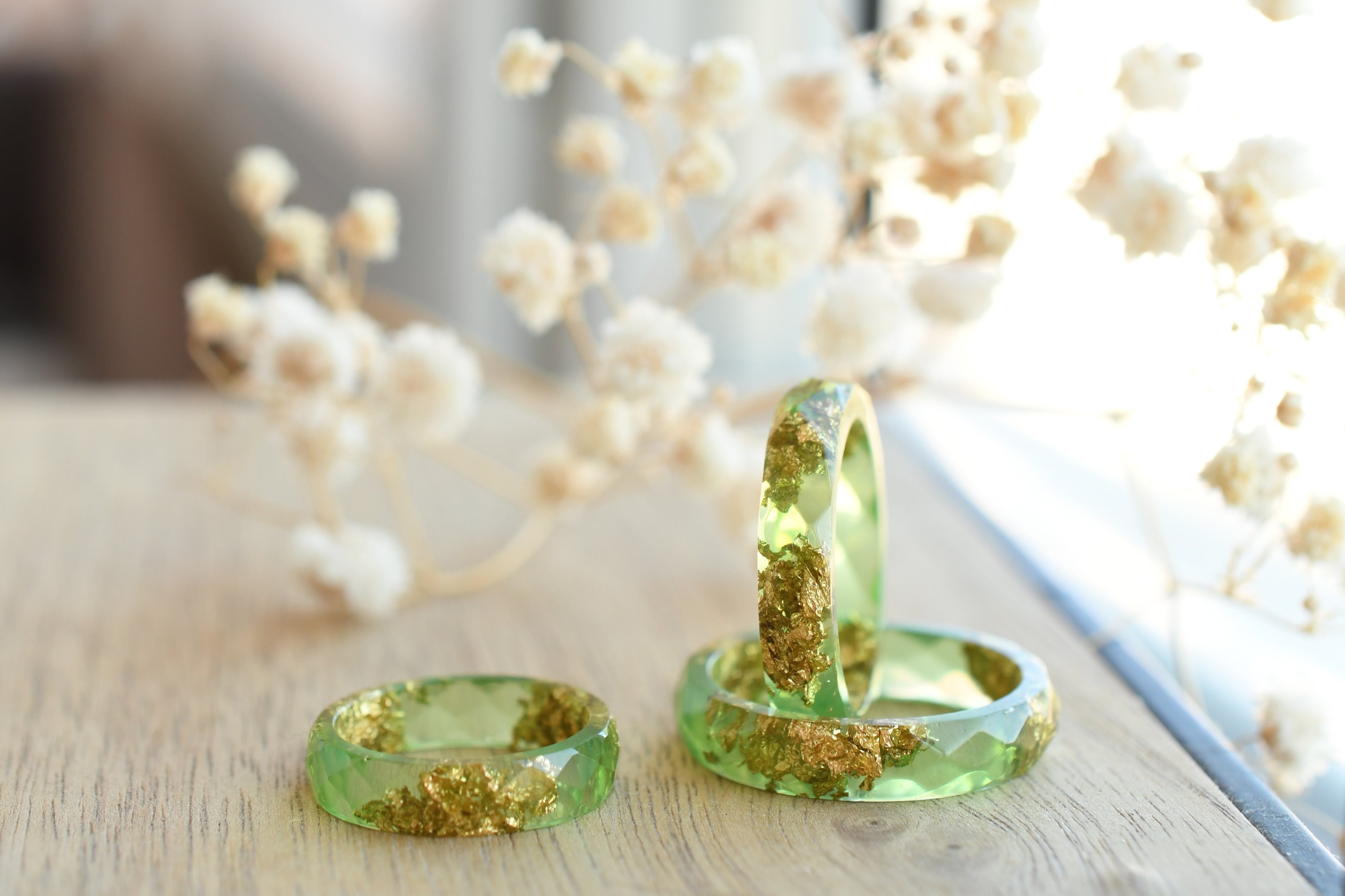 Close-up of real gold flakes suspended in light green resin handmade ring