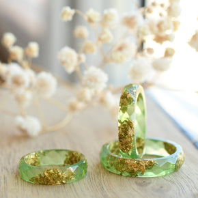 Close-up of real gold flakes suspended in light green resin handmade ring