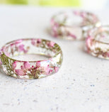 Faceted resin ring with real dried heather flowers on white background