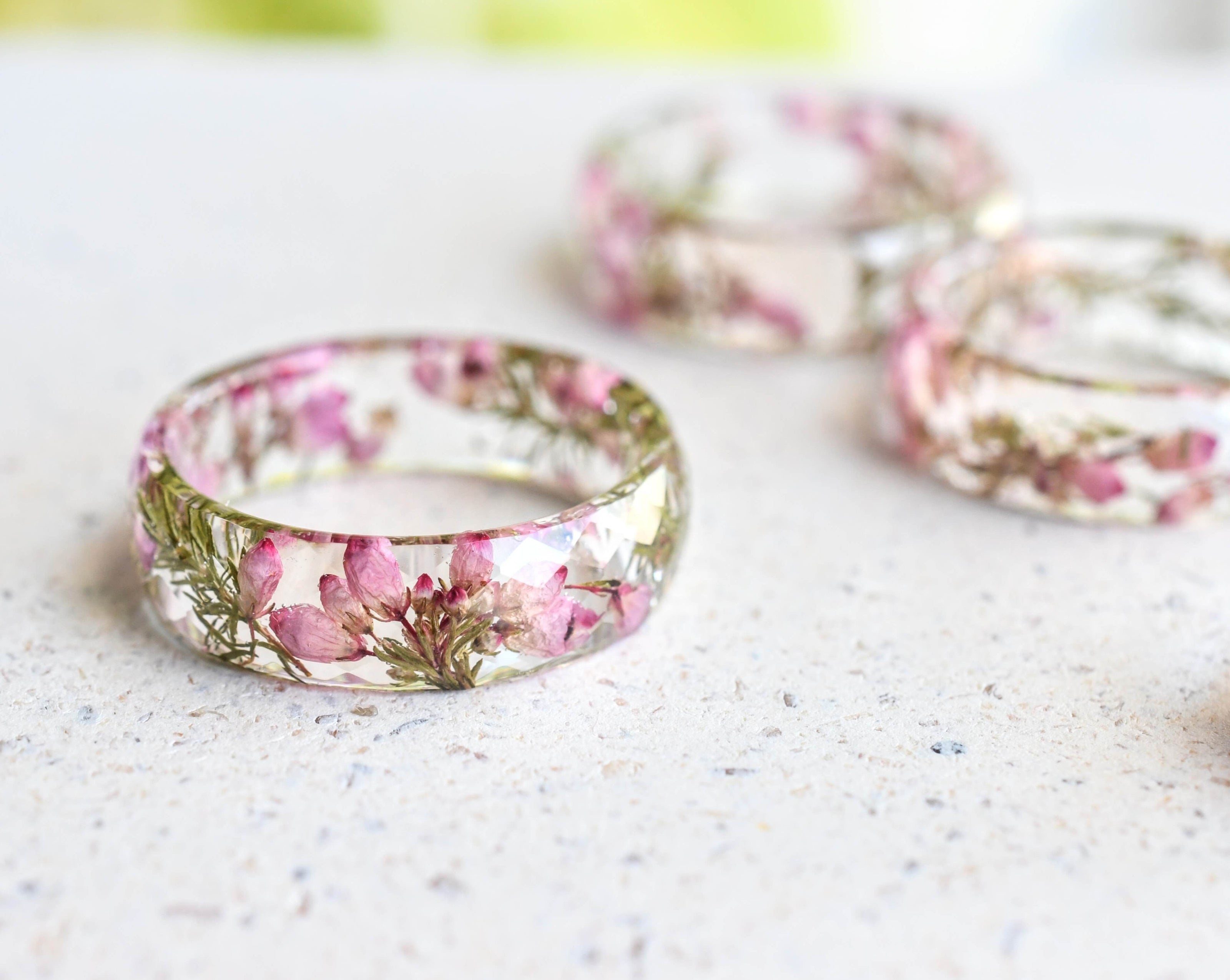 Faceted resin ring with real dried heather flowers on white background