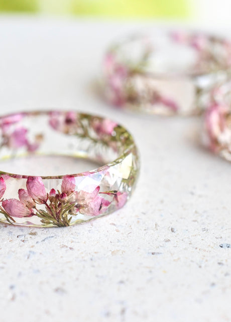 Faceted resin ring with real dried heather flowers on white background