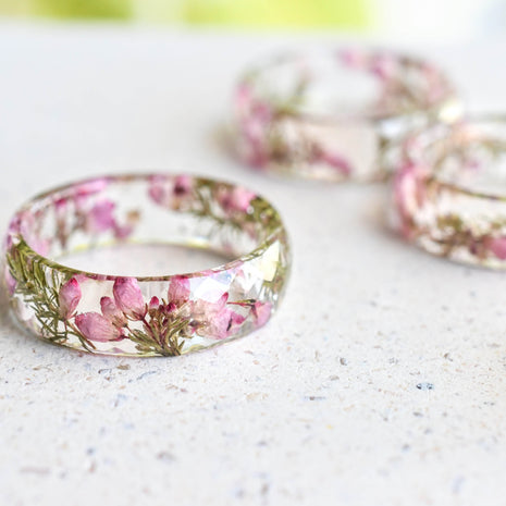Faceted resin ring with real dried heather flowers on white background