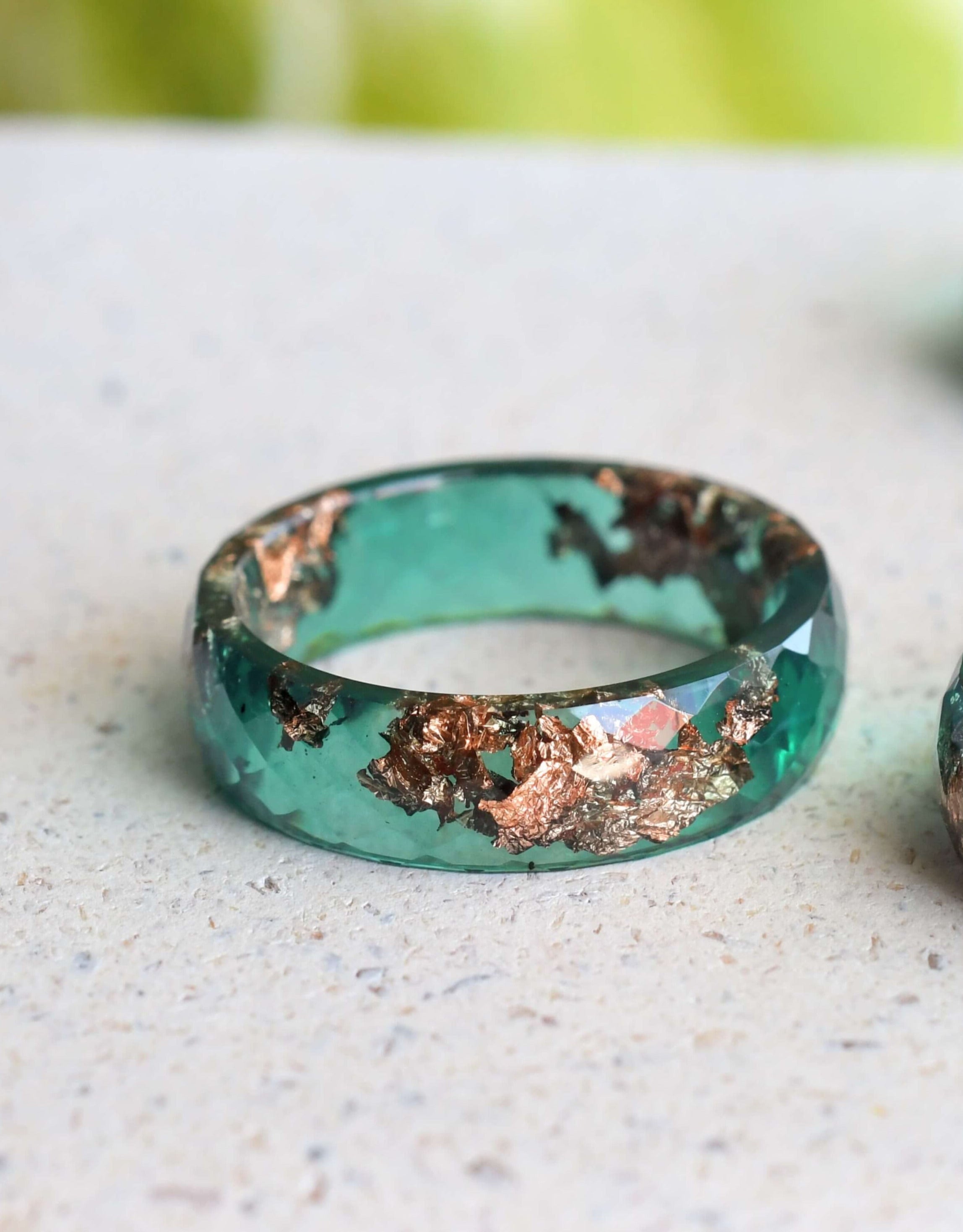 Jade resin ring with rose gold leaf on white background
