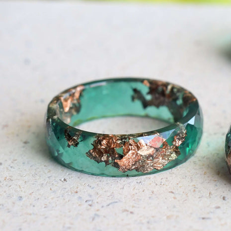 Jade resin ring with rose gold leaf on white background