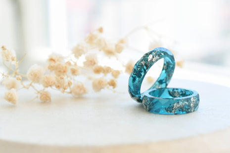 Flatlay of Ocean Signal Ring showing silver flakes in teal resin