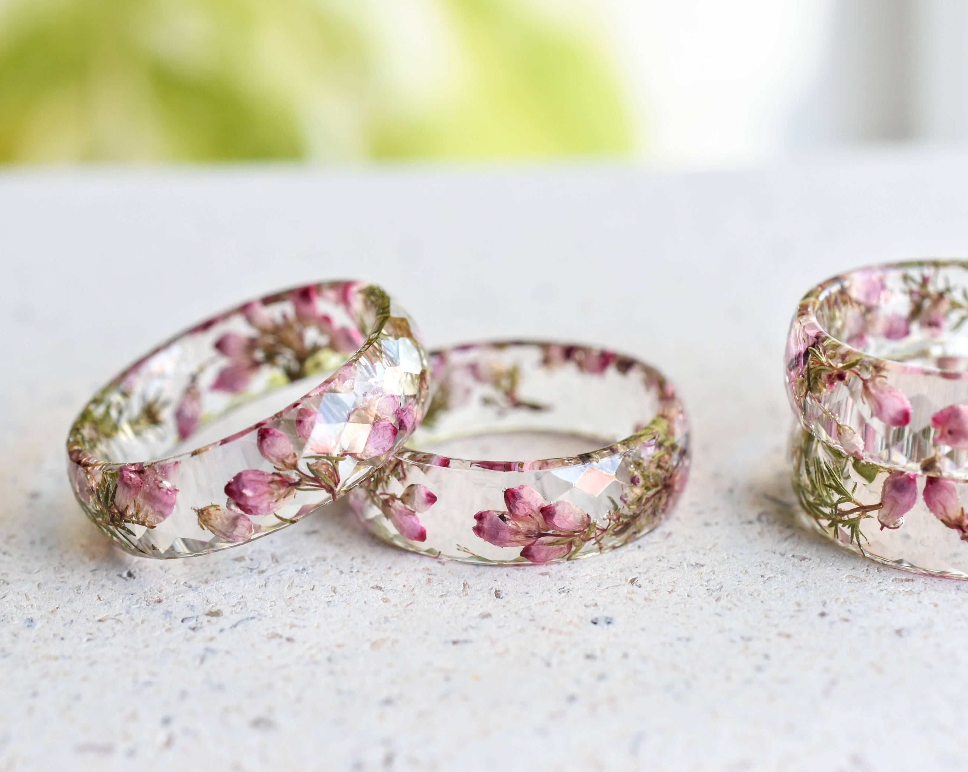 Close-up of heather flower and moss in clear resin ring