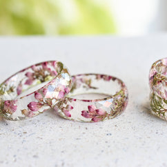 Close-up of heather flower and moss in clear resin ring
