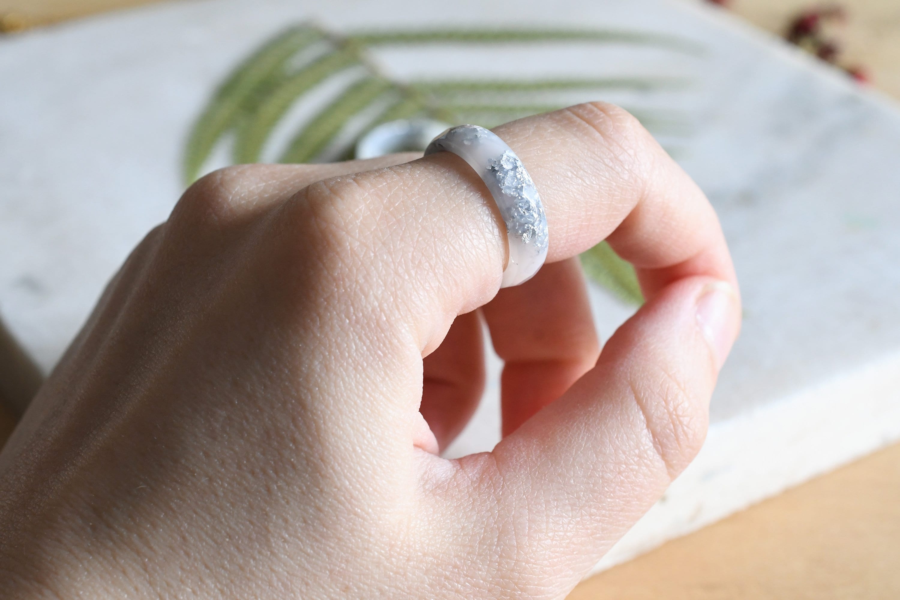 White resin ring with silver flakes worn on hand — unisex minimalist jewelry