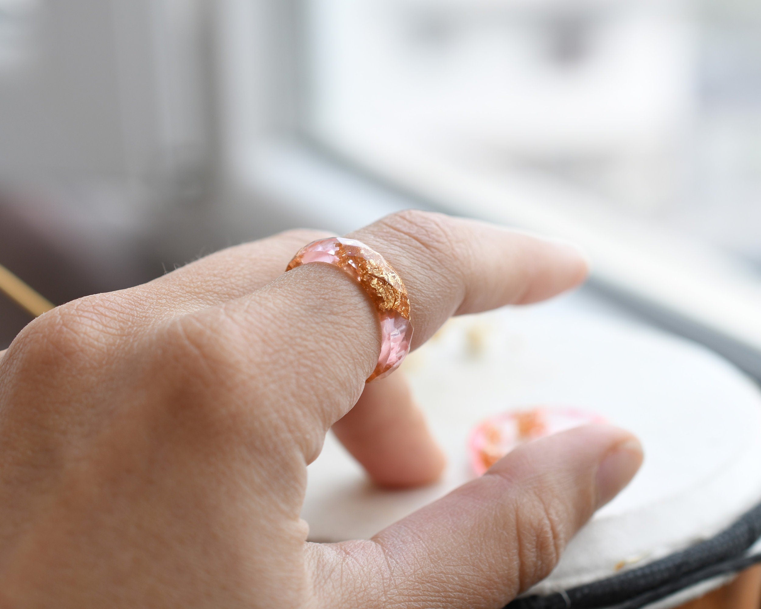 Pink resin ring with gold flakes worn on hand — unisex minimalist jewelry