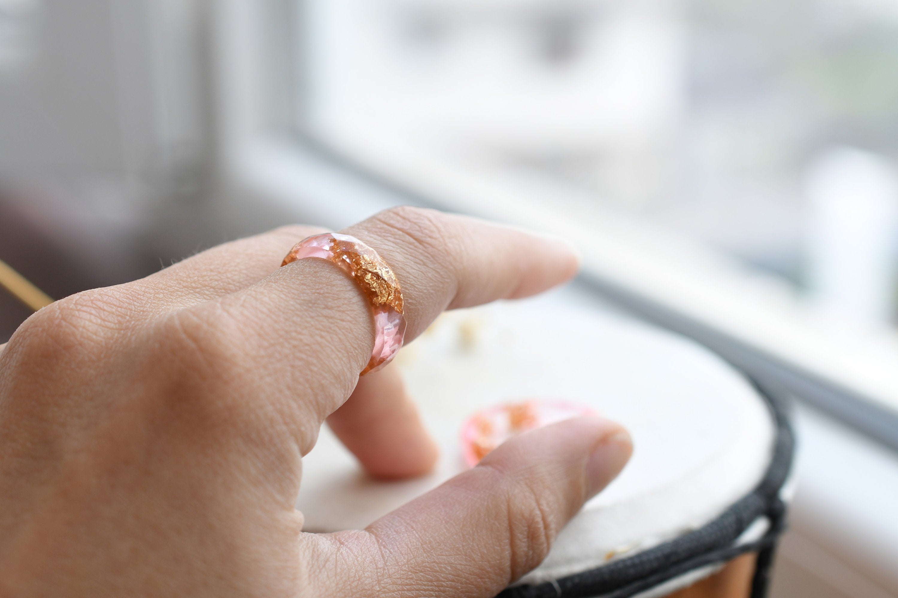 Pink resin ring with gold flakes worn on hand — unisex minimalist jewelry