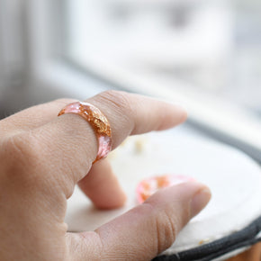 Pink resin ring with gold flakes worn on hand — unisex minimalist jewelry