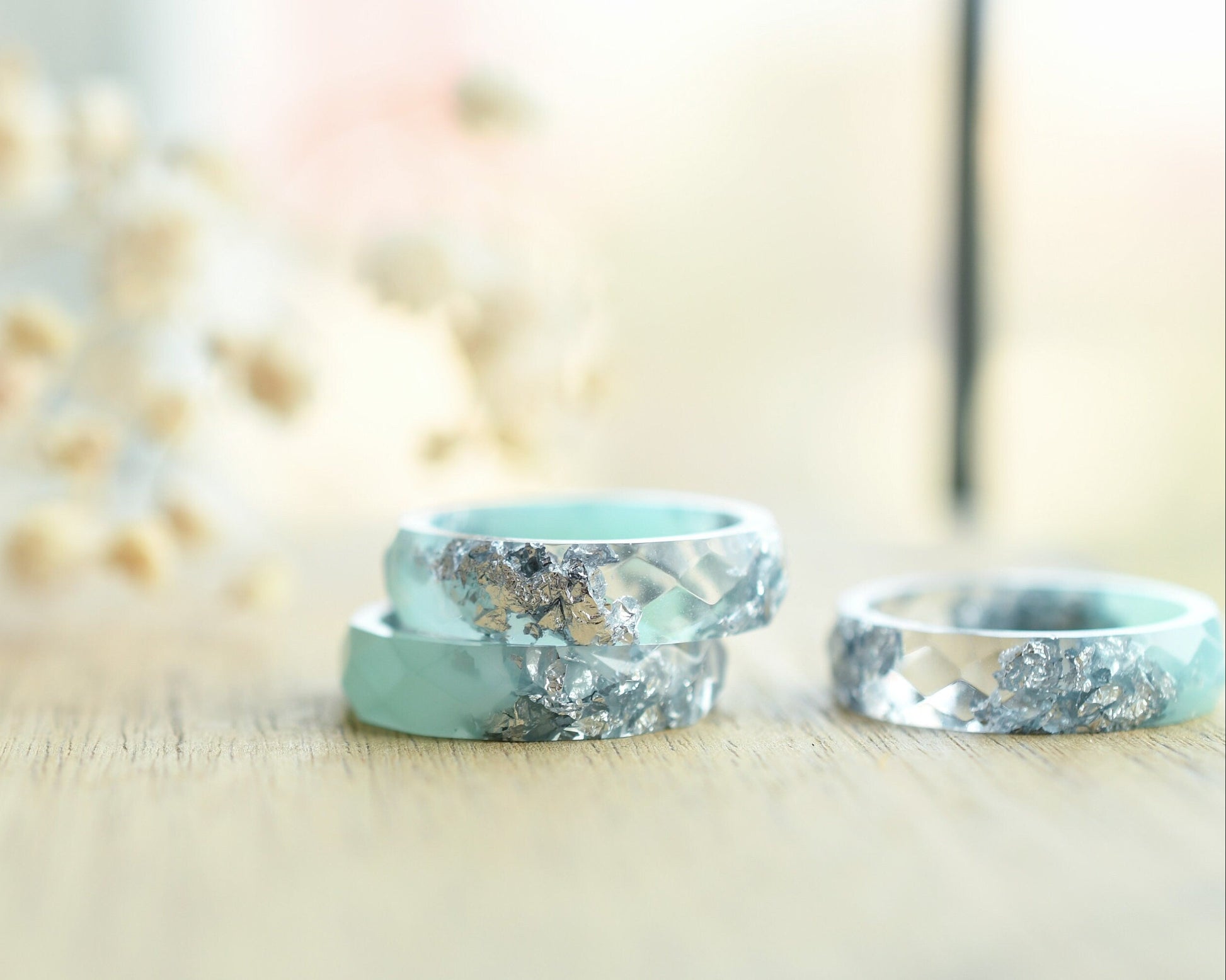 Close-up of silver flakes suspended in mint-tinted transparent resin handmade ring