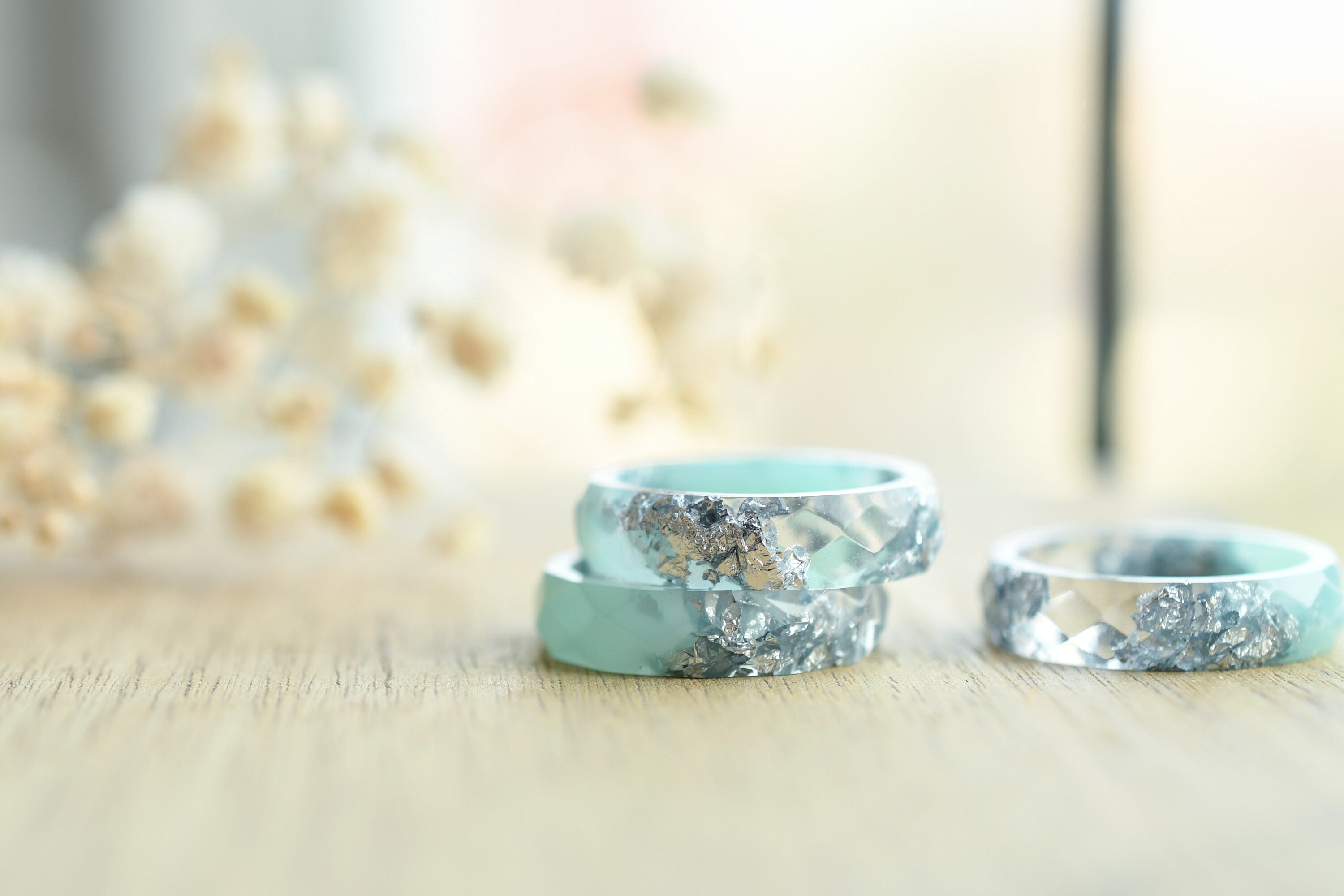 Close-up of silver flakes suspended in mint-tinted transparent resin handmade ring