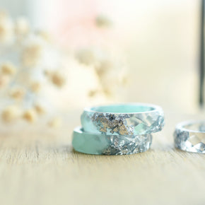 Close-up of silver flakes suspended in mint-tinted transparent resin handmade ring