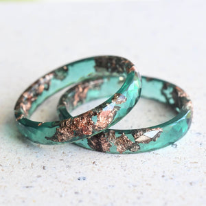 Flatlay of Jade Whisper Ring with rose gold accents in jade green resin