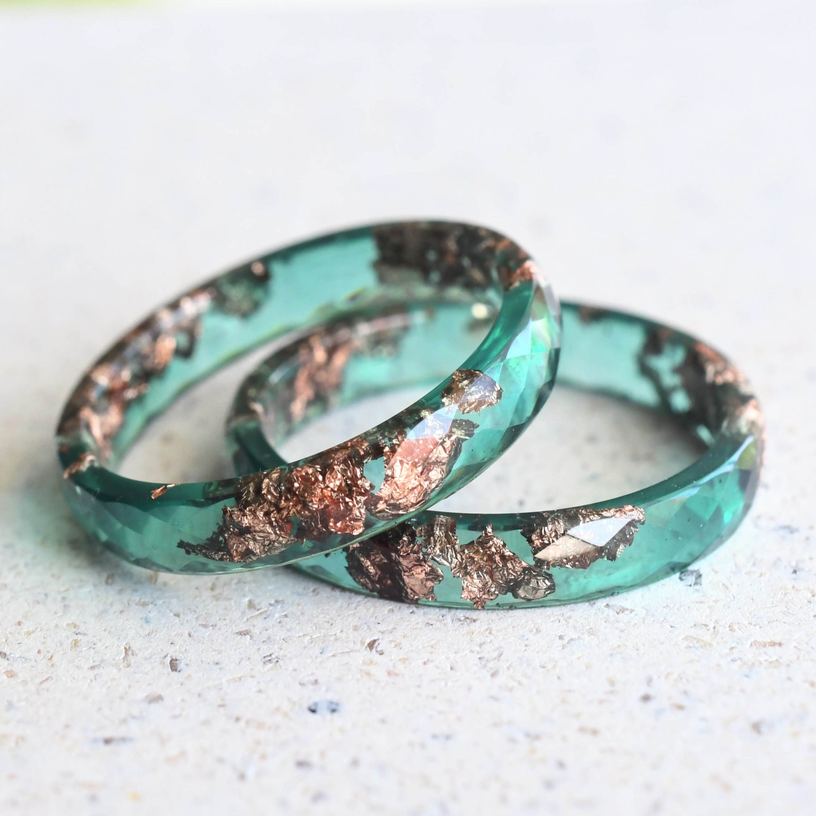 Flatlay of Jade Whisper Ring with rose gold accents in jade green resin