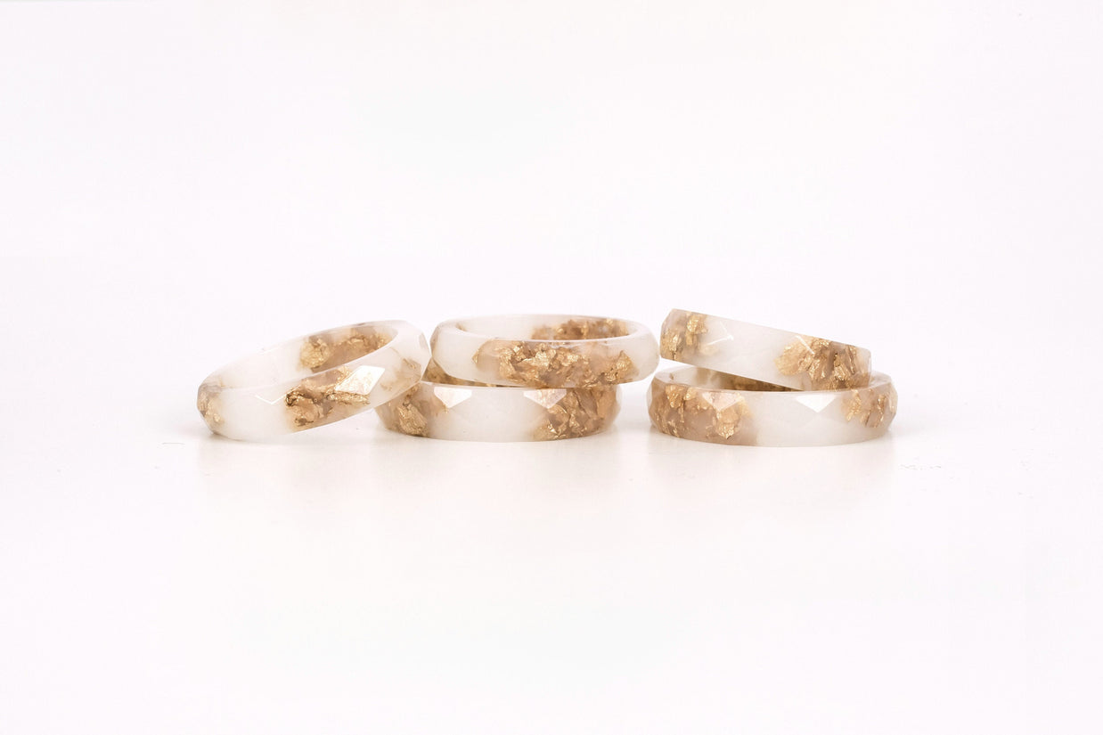 Close-up of gold flakes suspended in opaque white resin handmade ring