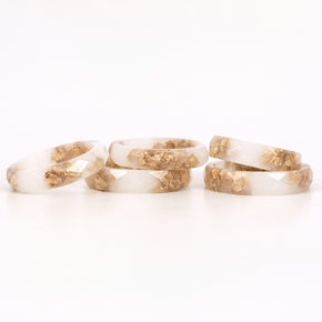 Close-up of gold flakes suspended in opaque white resin handmade ring