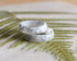 Close-up of silver flakes suspended in opaque white resin handmade ring