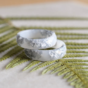 Close-up of silver flakes suspended in opaque white resin handmade ring